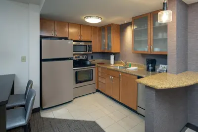 a kitchen with a white refrigerator and wooden cabinets at Residence Inn by Marriott Miami Airport in Miami