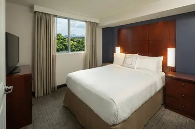 a hotel room with a large bed and a television at Residence Inn by Marriott Miami Airport in Miami