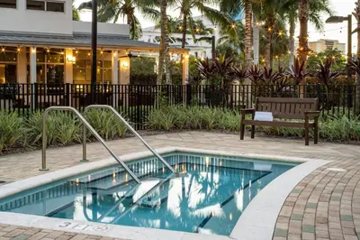 a swimming pool with a bench next to a building at Residence Inn by Marriott Miami Airport in Miami