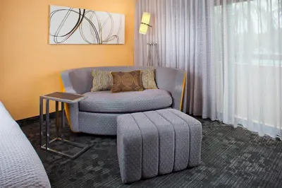 a living room with a chair and a table at Courtyard Miami Airport West Doral in Miami