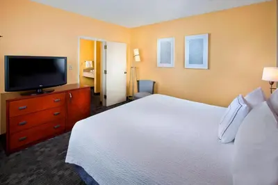 a bedroom with a large bed and a flat screen tv at Courtyard Miami Airport West Doral in Miami