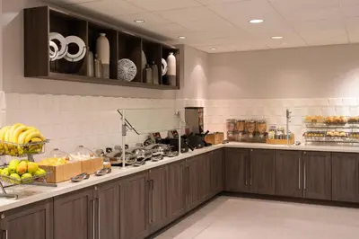 a large kitchen with wooden cabinets and bananas on the counter at SpringHill Suites Miami Downtown/Medical Center in Miami