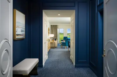 a hallway with blue walls and a room with a chair at Trump National Doral Golf Resort in Miami