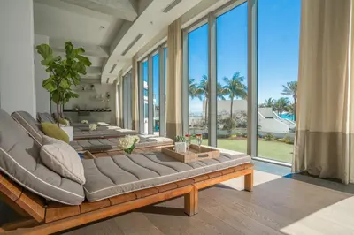 a living room with several couches and windows at Eden Roc Miami Beach in Miami Beach