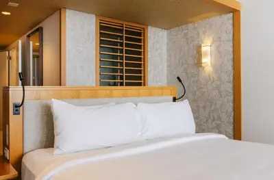 a bed with white pillows in a room at Eden Roc Miami Beach in Miami Beach