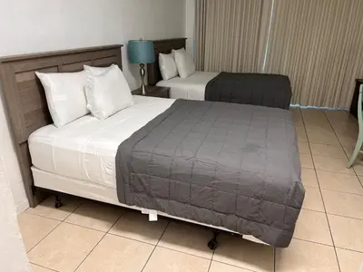 a hotel room with two beds and a lamp at Ocean Front Units at Miami Beach in Miami Beach