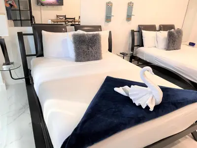 a room with two beds with a swan on them at Ocean Front Units at Miami Beach in Miami Beach