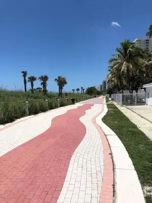 a red brick road with palm trees in the distance at Ocean Front Units at Miami Beach in Miami Beach