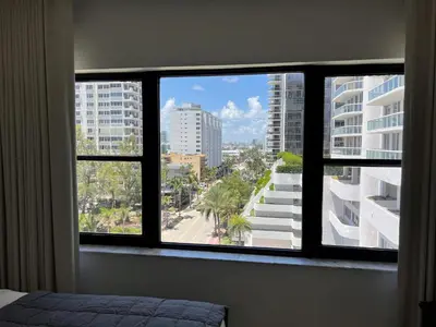a bedroom with a view of a city from a window at Ocean Front Units at Miami Beach in Miami Beach