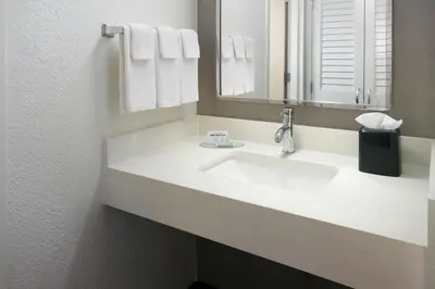a bathroom with a white sink and a mirror at Courtyard by Marriott Fort Lauderdale City of Plantation in Plantation