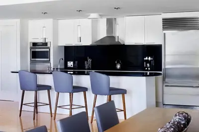 a kitchen with white cabinets and blue bar stools at The Ritz-Carlton, Fort Lauderdale in Fort Lauderdale