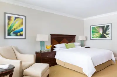 a white bedroom with a bed and a chair at JW Marriott Miami in Miami