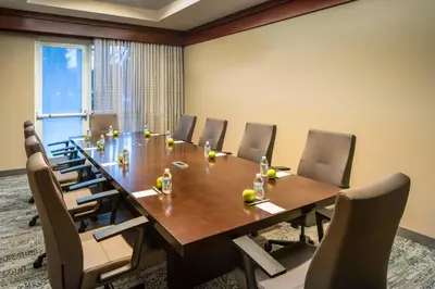a conference room with a long wooden table and chairs at Courtyard by Marriott Fort Lauderdale Airport & Cruise Port in Dania Beach