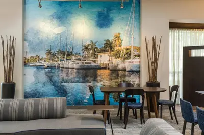 a living room with a painting of a harbor at Courtyard by Marriott Fort Lauderdale Airport & Cruise Port in Dania Beach