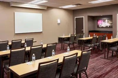 a conference room with tables and chairs and a whiteboard at Sonesta Select Miami Lakes in Miami Lakes