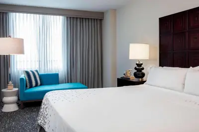 a hotel room with a bed and a blue chair at Renaissance Fort Lauderdale Cruise Port Hotel in Fort Lauderdale