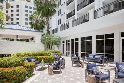 a patio at the resort with blue chairs and plants at Courtyard Miami Dadeland in Miami