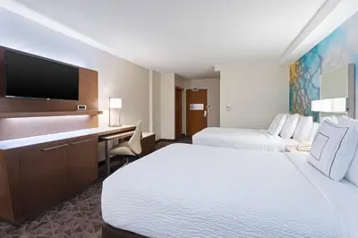 a hotel room with two beds and a desk and a tv at Courtyard Miami Downtown Brickell Area in Miami