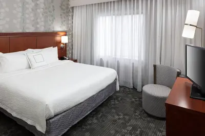 a hotel room with a bed and a television at Courtyard by Marriott Miami at Dolphin Mall in Miami