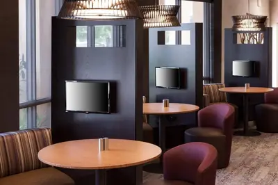 a restaurant with tables and chairs and a flat screen tv at Courtyard by Marriott Miami at Dolphin Mall in Miami