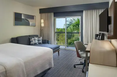 a hotel room with a bed and a desk at Courtyard by Marriott Fort Lauderdale Weston in Weston