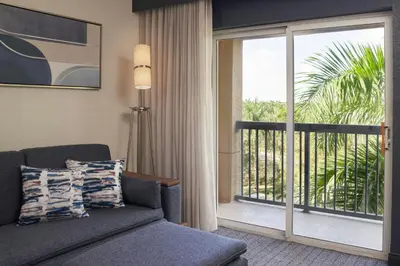 a living room with a couch and a sliding glass door at Courtyard by Marriott Fort Lauderdale Weston in Weston