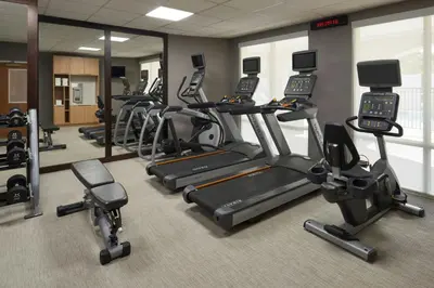 a gym with a row of treadmills and exercise bikes at Courtyard by Marriott Fort Lauderdale Weston in Weston