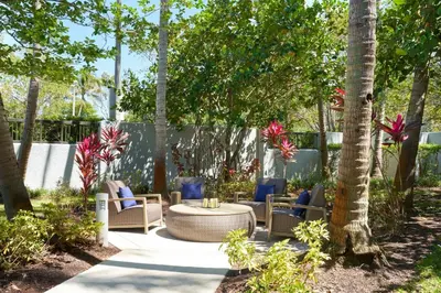 a patio with chairs and a table and trees at Courtyard by Marriott Fort Lauderdale Weston in Weston