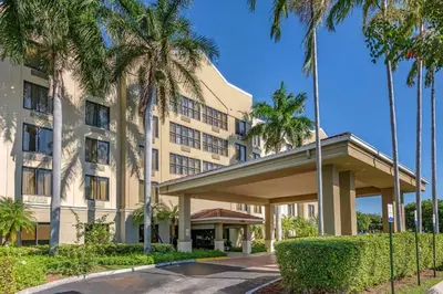 a hotel with palm trees in front of a building at Comfort Suites Miami - Kendall in Kendall