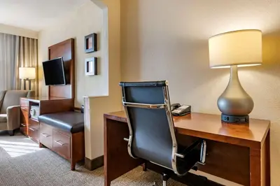 a hotel room with a desk with a chair and a lamp at Comfort Suites Miami - Kendall in Kendall