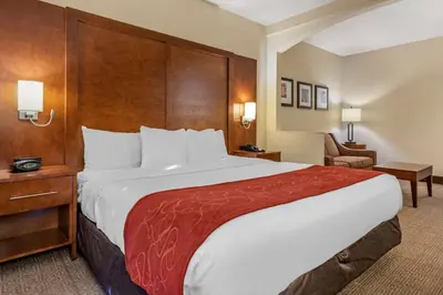 a hotel room with a large bed and a chair at Comfort Suites Miami - Kendall in Kendall