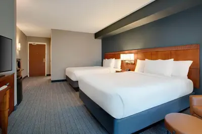 a hotel room with two beds and a flat screen tv at Courtyard Fort Lauderdale SW Miramar in Miramar