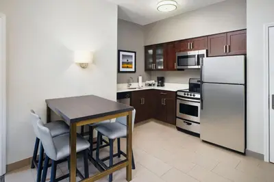 a small kitchen with a table and a refrigerator at Residence Inn by Marriott Fort Lauderdale City of Plantation in Plantation