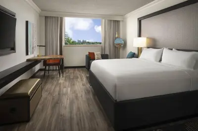 a hotel room with a large bed and a desk at Renaissance Fort Lauderdale West Hotel in Plantation