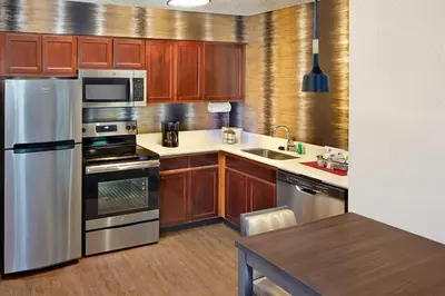 a kitchen with wooden cabinets and stainless steel appliances at Residence Inn by Marriott Fort Lauderdale Weston in Weston