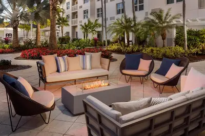 a patio with couches and chairs and a fire pit at Courtyard by Marriott Miami Aventura Mall in Aventura