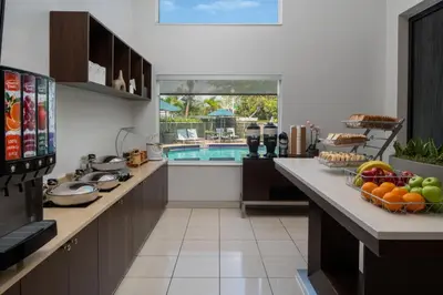 a kitchen with a pool and a table with fruit on it at SpringHill Suites Fort Lauderdale Airport in Dania Beach
