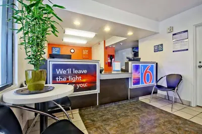 a restaurant with a counter and a table and chairs at Motel 6 Dania Beach in Dania Beach