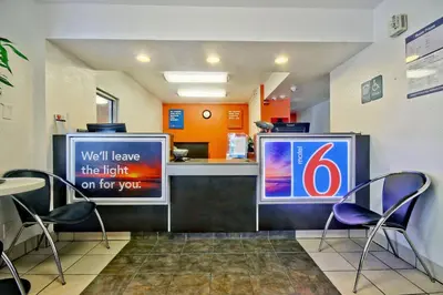 a restaurant with two chairs and a counter with a sign at Motel 6 Dania Beach in Dania Beach