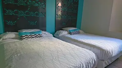 two twin beds in a room with blue walls at Miami Sun Hotel - Downtown/Port of Miami in Miami