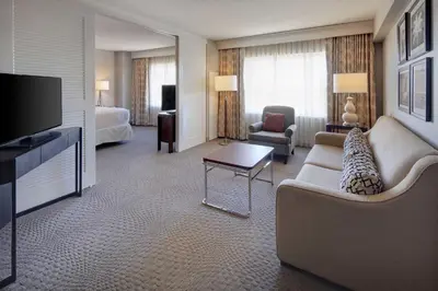 a living room with a couch and a television in a hotel room at Sheraton Suites Fort Lauderdale West in Plantation