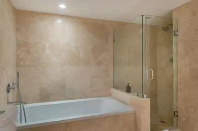 a bathroom with a tub and a glass shower at Oceanview Private Condo at 1 Hotel & Homes -1144 in Miami Beach