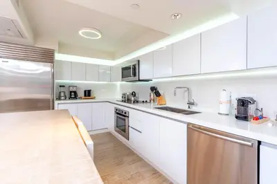 a kitchen with white cabinets and stainless steel appliances at Oceanview Private Condo at 1 Hotel & Homes -1106 in Miami Beach