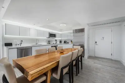 a kitchen and dining room with a wooden table and chairs at Oceanview Private Condo at 1 Hotel & Homes -1040 in Miami Beach