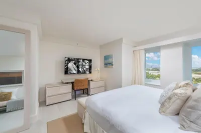 a white bedroom with a bed and a desk and a window at Luxurious Private Condo at 1 Hotel & Homes -1445 in Miami Beach
