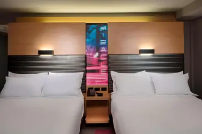 two beds with white pillows in a hotel room at Aloft Coral Gables in Miami