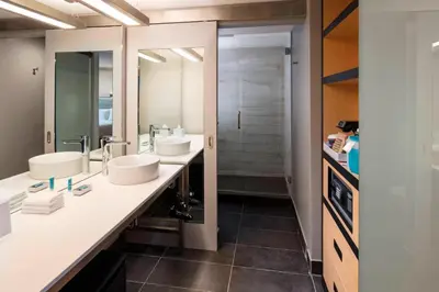 a bathroom with two sinks and a walk in shower at Aloft Coral Gables in Miami