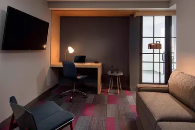 a room with a desk with a computer and a couch at Aloft Coral Gables in Miami