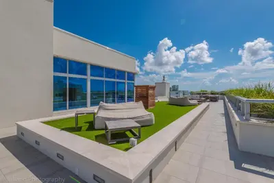 a patio with a bench and grass on a building at CH Luxury Condos & Studios On The Beach in Hollywood