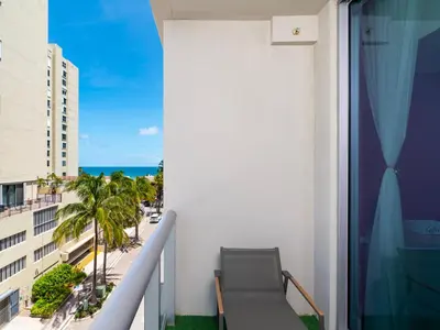 a balcony with a view of the ocean and palm trees at CH Luxury Condos & Studios On The Beach in Hollywood